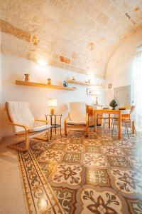 salon ze stołem i krzesłami na dywanie w obiekcie Fior di Giglio Historic House - Housea Travel w mieście Polignano a Mare