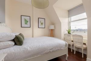 1 dormitorio con 1 cama, mesa y sillas en Stylish Victorian Apartment's close to the Botanical gardens, Free parking! en Edimburgo