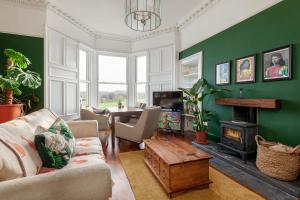 a living room with a couch and a fireplace at Stylish Victorian Apartment's close to the Botanical gardens, Free parking! in Edinburgh