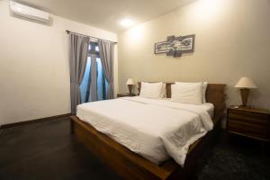 Un dormitorio con una cama grande y una ventana en Linggar House Canggu, en Canggu