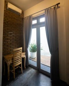 Habitación con puerta con silla y ventana en Linggar House Canggu, en Canggu