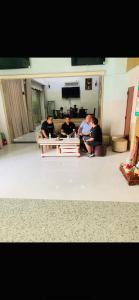 un grupo de hombres sentados alrededor de una mesa en una sala de estar en KHÁCH SẠN HOÀNG TRIỀU, en Chánh Long