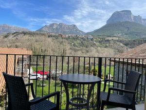 una mesa y sillas en un balcón con montañas en Hotel Cinca, en Escalona