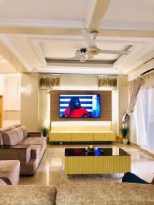 a living room with a couch and a tv at Apartment in Dar es salaam, Palm Village in Dar es Salaam