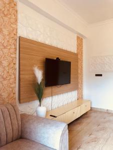 a living room with a flat screen tv on a wall at Apartment in Dar es salaam, Palm Village in Dar es Salaam