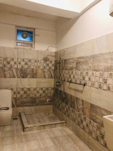 a bathroom with a shower and a toilet and a sink at Apartment in Dar es salaam, Palm Village in Dar es Salaam