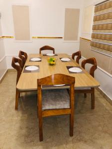 a wooden dining room table with wooden chairs at Apartment in Dar es salaam, Palm Village in Dar es Salaam