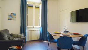 sala de estar con mesa y sillas azules en Ariento House by 360Rentals, en Florencia