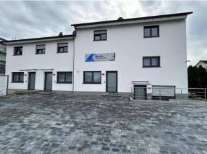 a large white building with a stone driveway at Milis Apartments in Radolfzell am Bodensee
