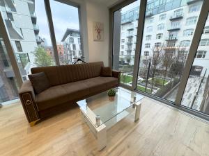 a living room with a couch and a glass table at Tower Bridge, London Luxury Flat with Beautiful Garden Views in London