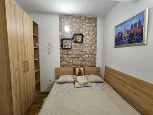 ヤホリナにあるApartman Viktor&Dariaのベッドとレンガの壁がある寝室