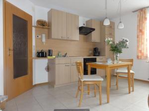 a kitchen with a wooden table and a table and chairs at Ferienwohnung Walter - Friedrichroda in Friedrichroda
