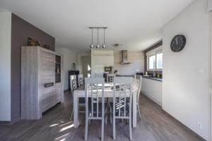 cocina y comedor con mesa y sillas en Les Vignets comfortable holiday home, en Sainte-Honorine-des-Pertes