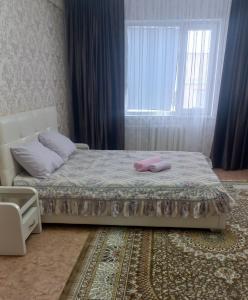 Un dormitorio con una cama con una toalla rosa. en Коктем 16, en Taldykorgan