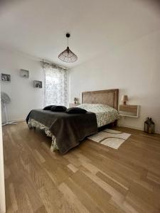 a bedroom with a bed and a wooden floor at Magnifique appartement à Rueil Malmaison in Rueil-Malmaison