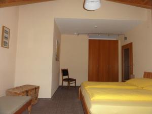 ein Hotelzimmer mit 2 Betten und einem Stuhl in der Unterkunft Ferienwohnung Walter - Friedrichroda in Friedrichroda