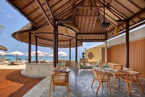 einen Essbereich im Freien mit Tischen, Stühlen und Sonnenschirmen in der Unterkunft Lembongan Beach Club & Resort in Nusa Lembongan