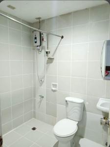 a bathroom with a shower with a toilet and a sink at VILLA LOURDES RESORT in Boracay