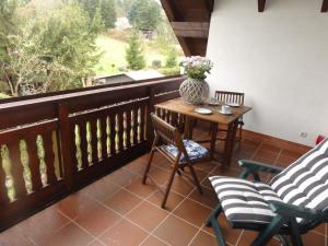 einen Balkon mit 2 Stühlen, einem Tisch und einer Vase in der Unterkunft Ferienwohnung Walter - Friedrichroda in Friedrichroda