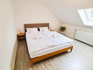 una camera da letto con un grande letto bianco con due cuscini di Apartment Nähe Airbus a Manching