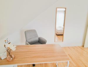 Zimmer mit einem Tisch, einem Stuhl und einem Spiegel in der Unterkunft Apartment Nähe Airbus in Manching