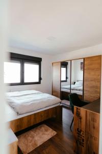 1 dormitorio con 1 cama grande y espejo en Apartman Marinela, en Belišće