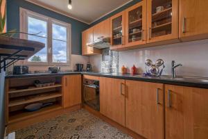 a kitchen with wooden cabinets and a sink and a window at Apart' Minnie - Disneyland Paris - 3 Bedrooms - Parking privé in Magny-le-Hongre