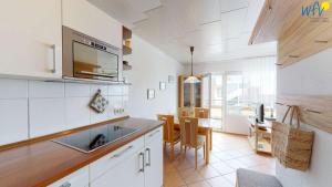 a kitchen with a sink and a table with chairs at Dünenschlösschen - Ferienwohnung 34 in Wangerooge