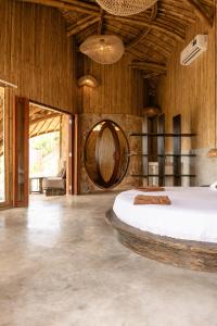 a bedroom with a bed and a wooden wall at Villa con Piscina Vista Mare - Lussuosa - Villa Chiara, Anima Eco Lodge in Selong Belanak