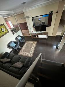 ein Wohnzimmer mit einem Sofa und einem Flachbild-TV in der Unterkunft Serra's Palace Hotel in Parauapebas