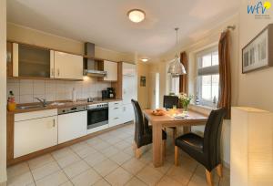 a kitchen with a wooden table and black chairs at Villa Cila Ferienwohnung 5 in Wangerooge