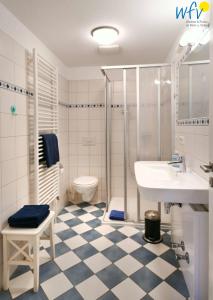 a bathroom with a sink and a shower and a toilet at Villa Cila Ferienwohnung 5 in Wangerooge +12 photos