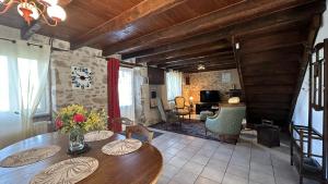 a living room with a wooden table and a living room at Le gite de nathye in Saint-Junien
