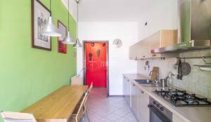 eine Küche mit einer roten Tür und einem roten Kühlschrank in der Unterkunft Rosmini house in Novara
