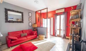 ein Wohnzimmer mit einem roten Sofa und einem Spiegel in der Unterkunft Rosmini house in Novara
