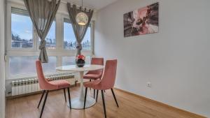 Deluxe City AS Apartment - FREE PARKING في زغرب: غرفة طعام مع طاولة وأربعة كراسي