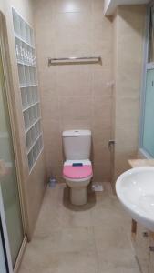 a bathroom with a pink toilet and a sink at Property King in Singapore
