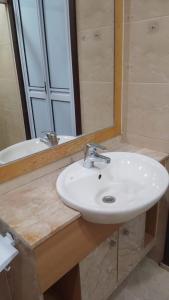 bagno con lavandino bianco e specchio di Property King a Singapore