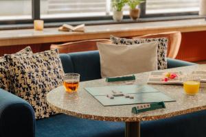 a table with two glasses and a book on it at City Hotel Hengelo in Hengelo