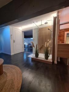 uma casa de banho com chuveiro e duas plantas em La casa cosy love, avec jacuzzi et sauna privés em Palau-del-Vidre