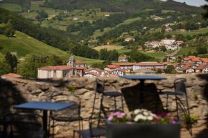 a group of tables and chairs on top of a stone wall at Iriarte Jauregia in Bidegoian