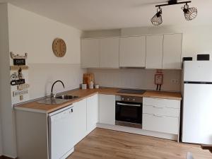 a kitchen with white cabinets and a sink and a refrigerator at Casa Raios de Sol in Burgau