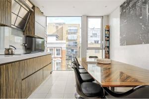 een keuken met een grote houten tafel en stoelen bij Multi-Award Winning 7 Storey Home - Near Shoreditch in Londen