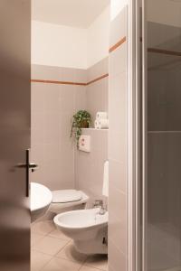 a white bathroom with a toilet and a sink at The Convo Lake Como in Como