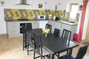 a kitchen with a black table and chairs in a kitchen at Gîte à la campagne in Ciron