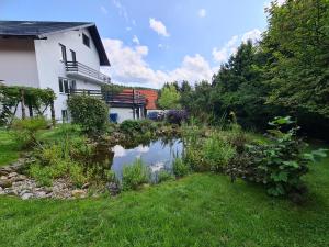 a house with a pond in the yard at Heart of Polen appartements in Piechowice