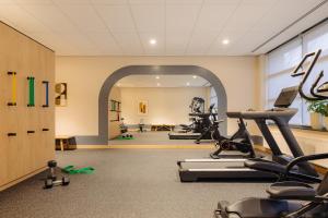 un gimnasio con cintas de correr y bicicletas estáticas en una habitación en City Hotel Hengelo en Hengelo