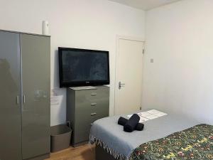 Uma TV ou centro de entretenimento em Rooms in a shared accommodation with Netflix, 10 min walk to LFC