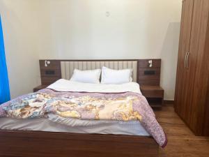 Un dormitorio con una cama con una manta encima. en F s kasauli, en Solan