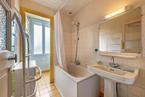 a bathroom with a tub and a sink and a bath tub at Maison 15pers 300m de la plage in Crozon +26 photos